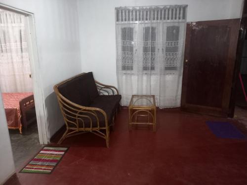 a living room with a chair and a table at Volunteer lanka in Padukka