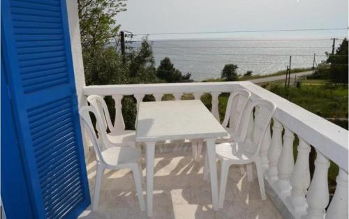 a white table and chairs on a balcony with the ocean at Hotel Paraktio in Nea Kalikratia