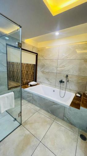 a bathroom with a shower and a bath tub at HOTEL JD HEAVENS in Jhajjar
