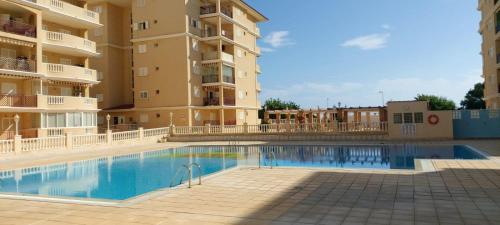 a swimming pool in front of some apartment buildings at SOLMAR La Mata Beach in Torrevieja
