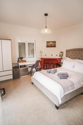 a bedroom with a large bed and a desk at SeaSuites Artemida in Artemida