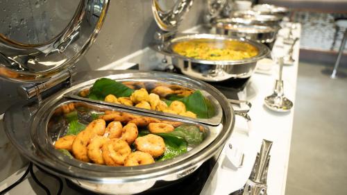 a buffet of food with shrimp and vegetables on a table at Zip By Spree Hotels Samudra Belgaum in Belgaum