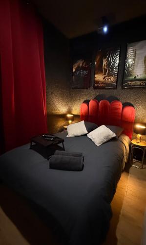 a bedroom with a large bed with a red headboard at Ciné Room Home Cinema Netflix Experience in Lunel