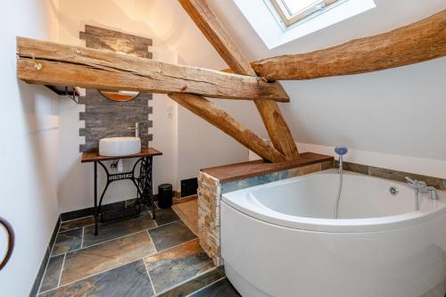 a bathroom with a large tub in a attic at Sur Les Roches in Dracy-lès-Couches