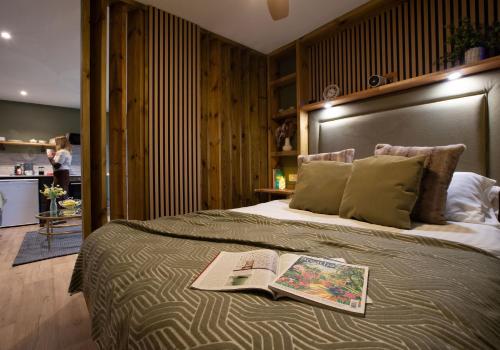 a bedroom with a bed with a book on it at City to Country Retreat Luxury Lodges with Hot Tub, BBQ, Fire Pit in Toppesfield