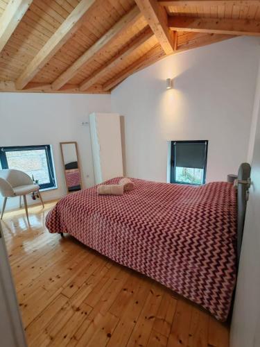 a bedroom with a bed and a wooden floor at O Cantinho da Penetra AL in Santar