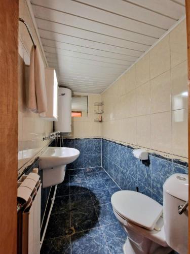 a bathroom with two sinks and a toilet in it at The House in Stoykite