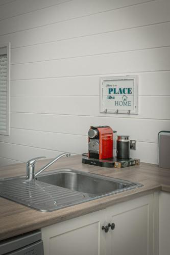 a kitchen sink with a red toaster on a counter at Hideaway Cottage, Tauranga, so close to Bethlehem & Mount Maunganui in Tauranga