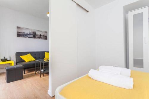 1 dormitorio con cama amarilla y sofá en Villa de Indias, en Sevilla