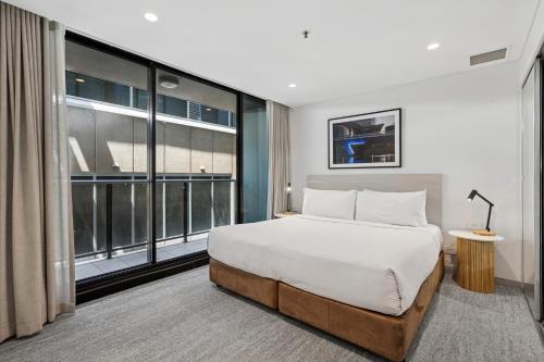 a bedroom with a bed and a large window at Urban Oasis City 2 Bed Apartment Oaks Horizons in Adelaide