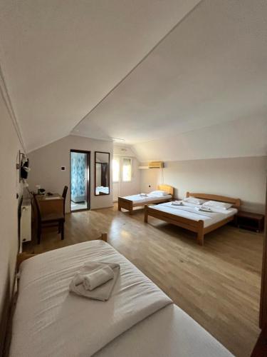 a large room with two beds and a desk at Guest house Vila Bor in Novi Sad