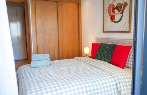 a bedroom with a bed with red and green pillows at Les princesses studio confort-plus charme in Maarif