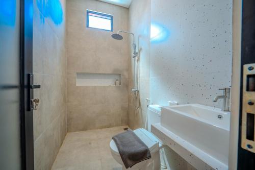 a bathroom with a toilet and a sink at Wana Kubu Suite and Dormitory in Ngurah Rai International Airport
