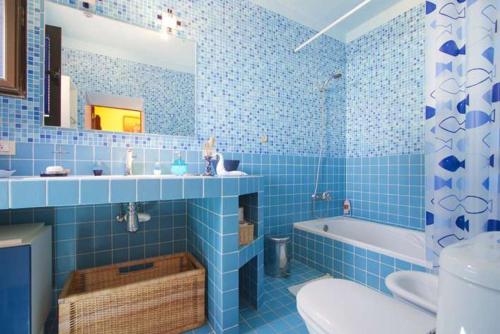 bagno piastrellato blu con vasca e lavandino di Villa Vista Graciosa a Las Laderas