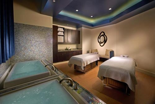 a bathroom with two beds and a bath tub at Wyndham Grand Orlando Resort Bonnet Creek in Orlando
