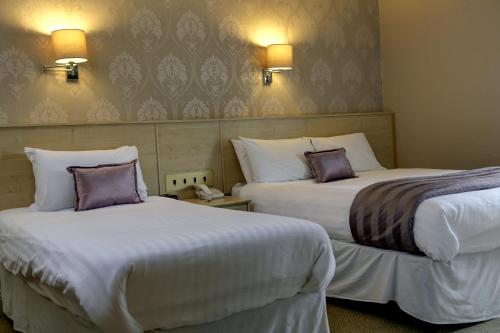 a hotel room with two beds and two lamps at Best Western New Kent Hotel in Newcastle upon Tyne