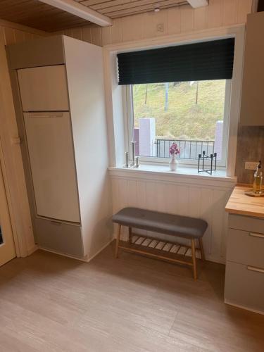 a kitchen with a bench in front of a window at The Cozy red house with Amazing sea view in Morskranes