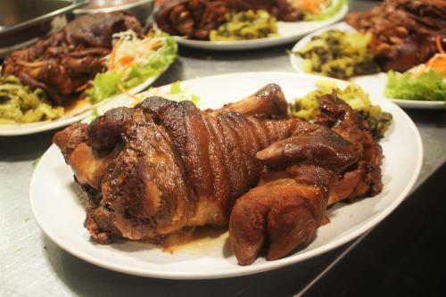 un plato de comida con carne y verduras en una mesa en Metro Hotel & Spa, en Thung Song