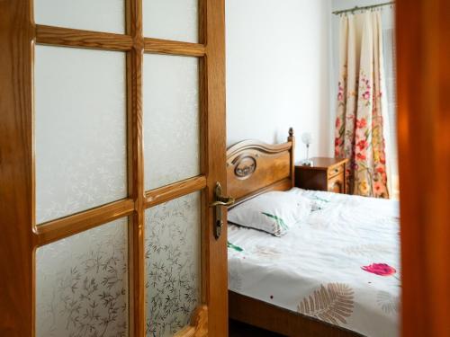 a door leading to a bedroom with a bed at Casa de vacanță in Călimăneşti