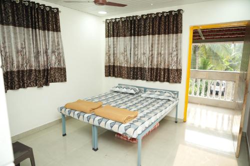 a bed in a room with a window at Swayam Beach Nivas in Srīvardhan