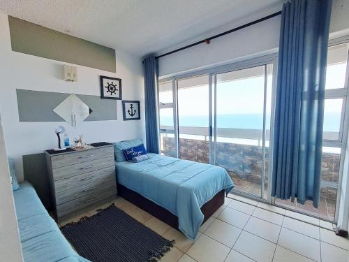a bedroom with a bed and a large window at Stella Maris 135 in Amanzimtoti