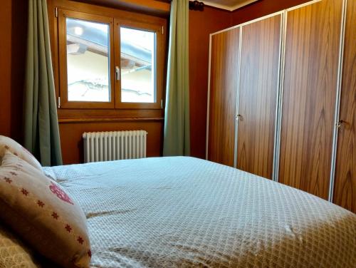 a bedroom with a bed and a window at La Cloche in Valtournenche
