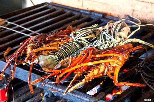 a group of lobsters cooking on a grill at Luxury Sakina Villa - Beachfront in Dzamandzar