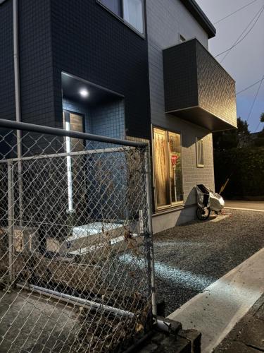 a chain link fence in front of a house at 智翔はうす 駐車場無料 民泊で女性家主滞在型 予約後はメール確認願います in Kumamoto