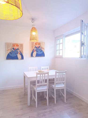 a white dining room with a white table and chairs at Apartamento Maruja Mallo in Viveiro