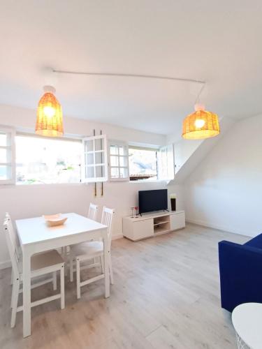 a living room with a white table and a tv at Apartamento Maruja Mallo in Viveiro
