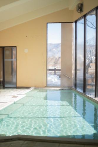ein leerer Swimmingpool mit einem großen Fenster in der Unterkunft Hotel Goryukan in Hakuba