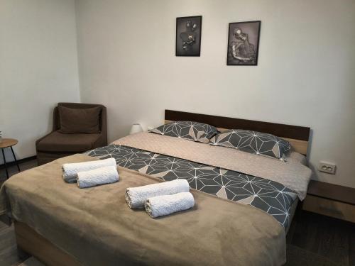 a bedroom with two beds and a chair at Pleven View in Pleven