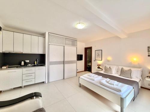 a bedroom with a large bed and a kitchen at Apartments Villa Stefan in Budva