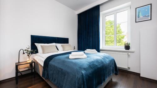 a bedroom with a bed with two towels on it at Flatbook Comfort Old Town 8 in Gdańsk
