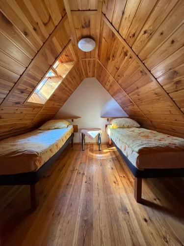 two beds in a room with a wooden ceiling at Kama Pobierowo in Pobierowo