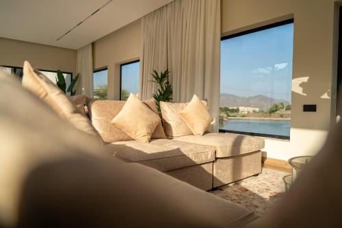 a living room with a couch and a large window at SS Resorts - Private Luxury Villa in Hatta