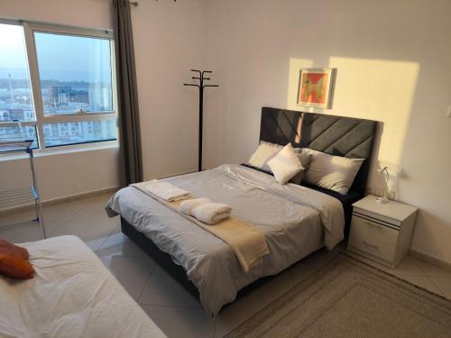 a bedroom with a large bed with a large window at Smart Home Vacation Home- AYLA in Sharjah