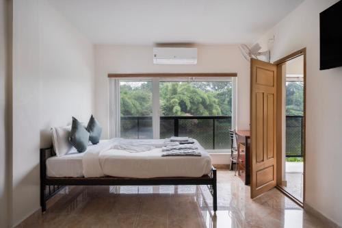 a bedroom with a bed and a large window at Tranquil Riverview Inn in Kottayam