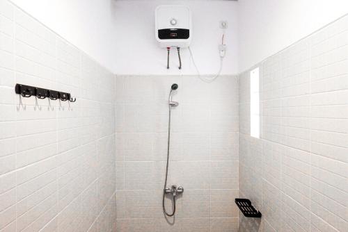 a bathroom with a shower with a camera on the wall at RedDoorz near Bukitsari Semarang in Jatingaleh