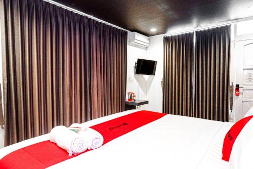 a hotel room with a bed and a television at RedDoorz near Bukitsari Semarang in Jatingaleh