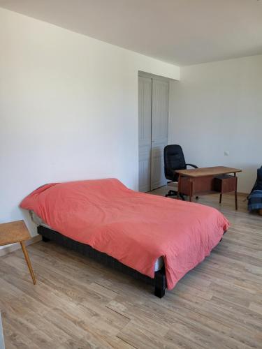 a bedroom with a red bed and a desk at Lieu charmant in Gimeux