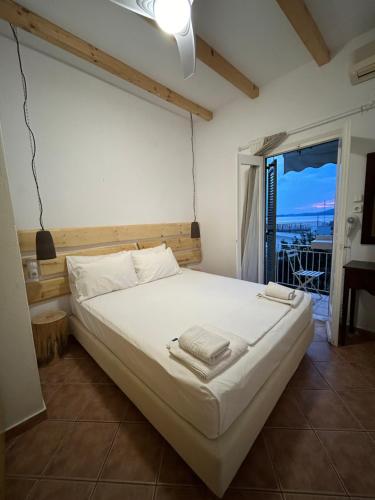 a bedroom with a bed with a view of the ocean at SEA HOME Accommodation in Loutraki