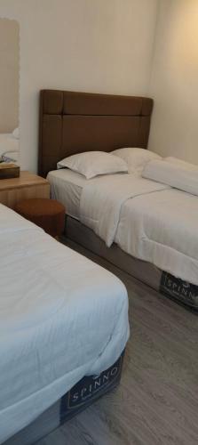 two beds in a hotel room with two bedsskirts at MEWAH guest house in Karangploso