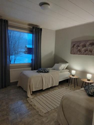 a bedroom with two beds and a large window at Björktorpet och Soltorpet in Lepplax