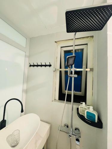a bathroom with a shower and a sink and a window at Silk Homestay LVC Central in Hanoi