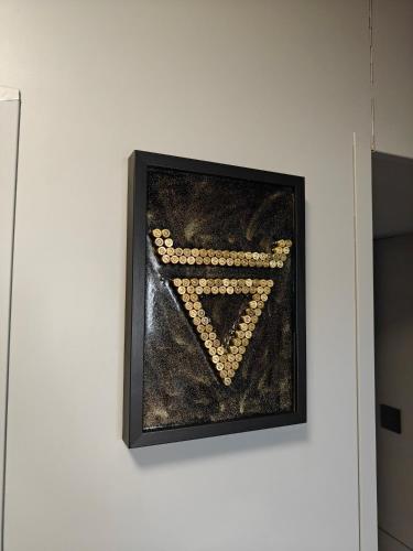 a picture on a white wall with a painting of a v at Apartament WELES in Bolesławiec