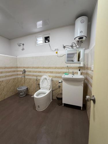 ein Badezimmer mit Toilette und Waschbecken in der Unterkunft Baas Basai in Kalimpong