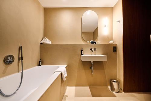 a bathroom with a tub and a sink and a mirror at Romantik Hotel le Val d'Amblève in Stavelot