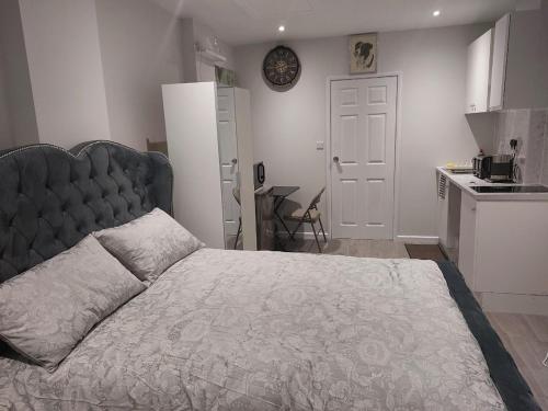 a bedroom with a large bed and a kitchen at Serene and Cosy Private Studio in Milton Keynes