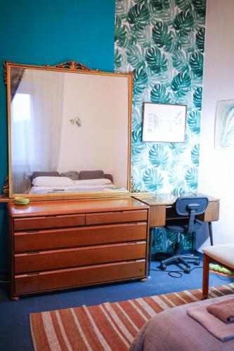 a bedroom with a bed and a desk with a mirror at Monstera room Vicino al centro in Perugia
